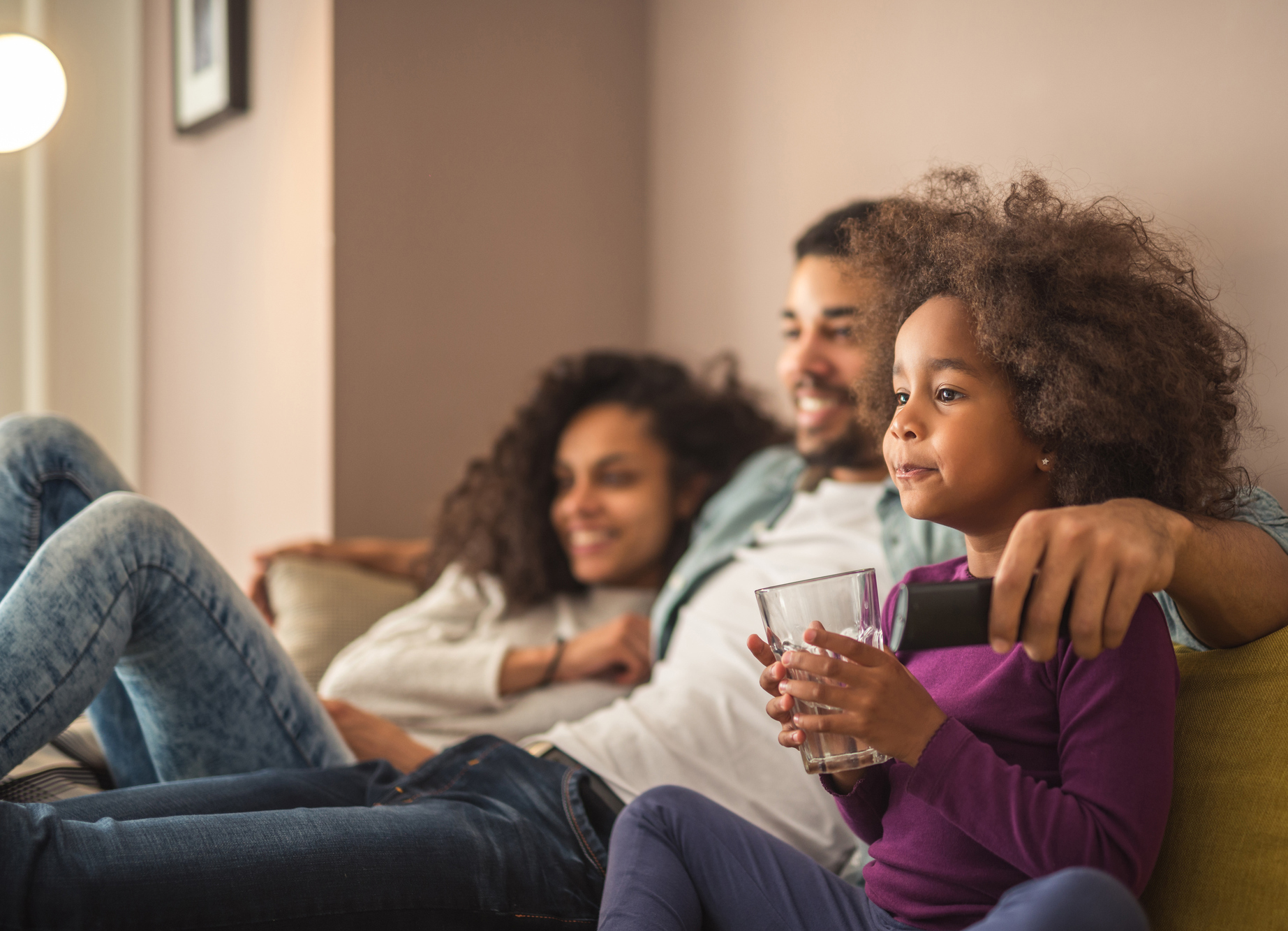Happy african american family relaxing and watching tv.